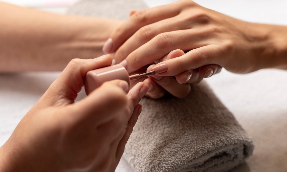 close-up-manicurist-applying-nail-polish